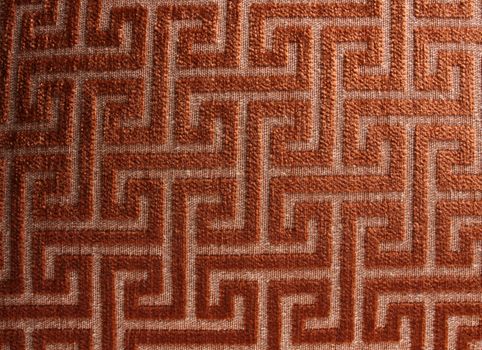 A background of a fabric with a pattern of a maze on it.