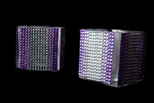 A pair of beautiful candle stands studded with artificial gemstones, on black studio background.