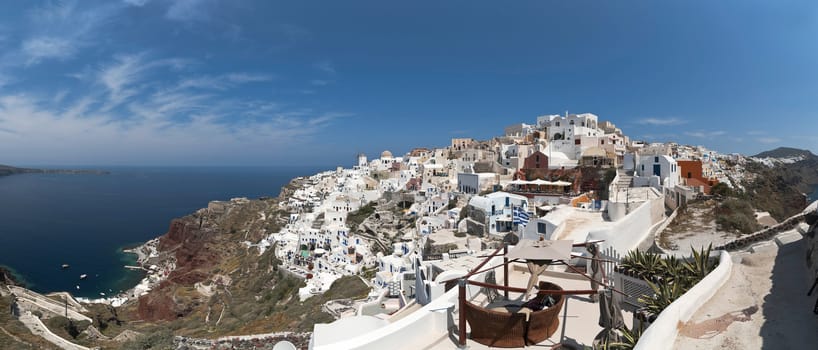 Santorini Ia panorama with typical architecture houses and greek flag