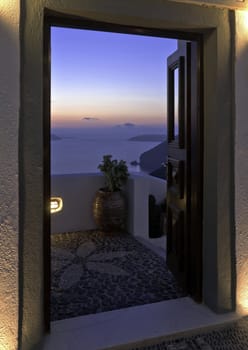 Santorini Caldera twilight view with cliffs trough the open door of the building