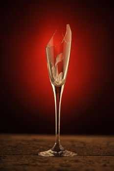 broken wine glass , red light on background