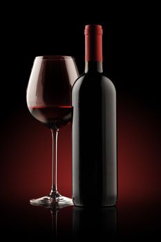 red wine bottle and wine glass , red light on background