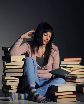 Cute girl studying with a big stack of books