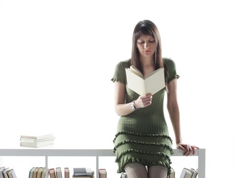 young woman with long hair, holding an open book, read against the white background 