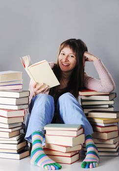 Cute girl studying with a big stack of books