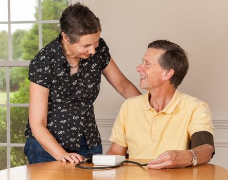 Senior caucasian retired male taking blood pressure at home