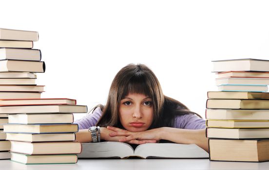 Tired of studies, young Woman is sitting on her desk with books 
