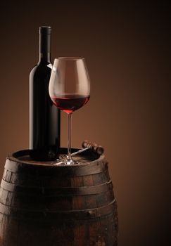 red wine bottle and wine glass on wodden barrel