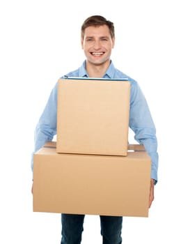 Young man holding cardboard boxes and smiling at the camera