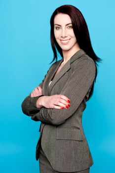 Attractive woman standing with crossed arms isolated on blue background