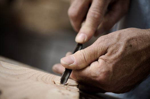 hands of the craftsman carve a bas-relief with a gouge