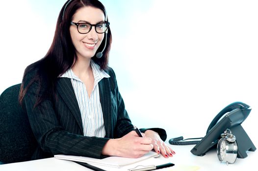 Female customer support executive at her work desk writing clients complain