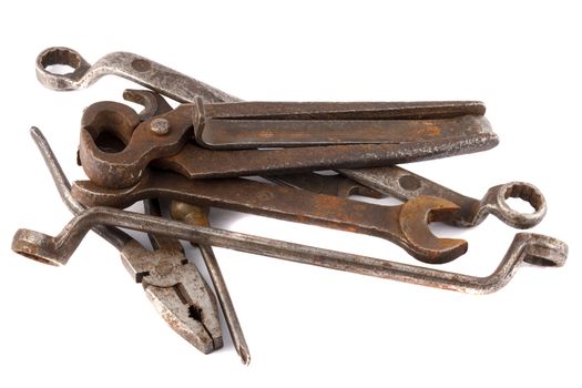 pile of old rusted wrenches and other tools on white background
