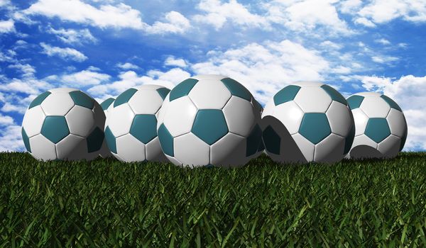 Cyan soccer balls on a green grass - outdoors