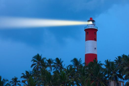 Lighthouse in night with light beam