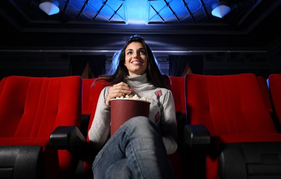 watching a movie at the cinema: portrait of a pretty girl in a movie theater
