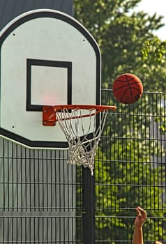 Attempting to score a goal at basketball, outdoors