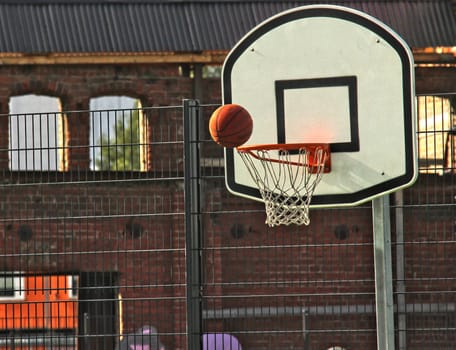 Attempting to score a goal at basketball, outdoors