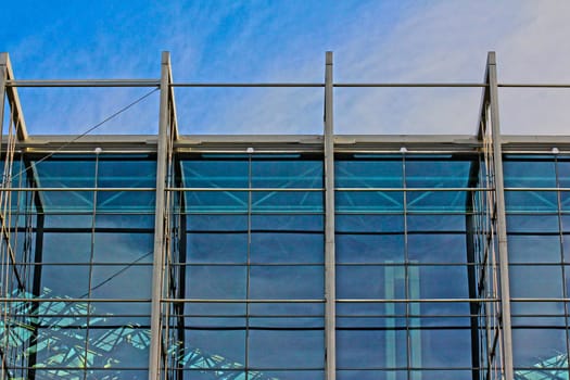 Modern blue glass wall of skyscraper, towards blue sky