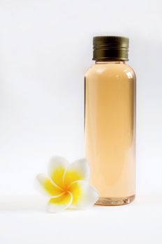 close up of  bottle and  frangipani on white background