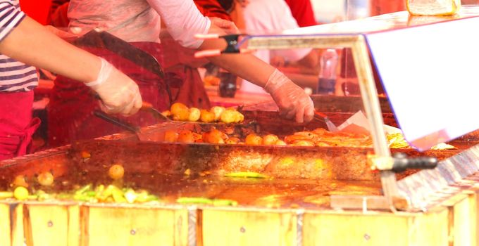 Chefs cooking at an outdoor restaurant, closeup