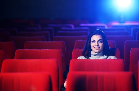 watching a movie at the cinema: portrait of a pretty girl in a movie theater