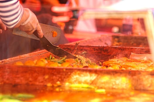 Chefs cooking at an outdoor restaurant, closeup