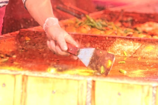 Chefs cooking at an outdoor restaurant, closeup