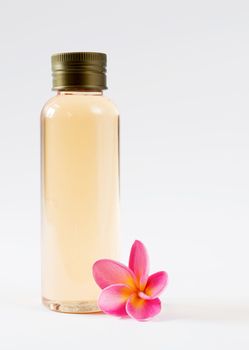 close up of  bottle and  frangipani on white background