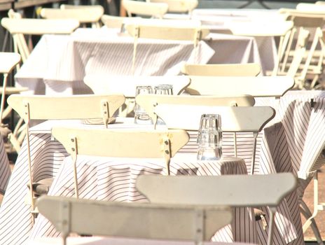 White chairs and tables, outdoors at a restaurant