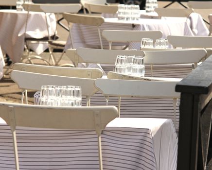 White chairs and tables, outdoors at a restaurant