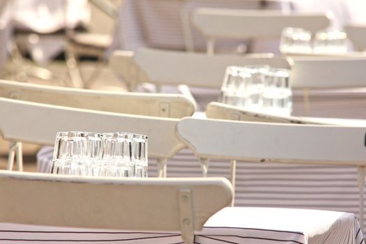 White chairs and tables, outdoors at a restaurant