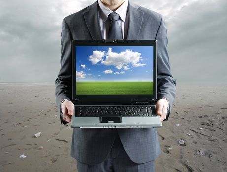 environment concept: Businessman holding his laptop