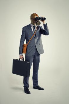 Businessman with gas mask  looking through binoculars