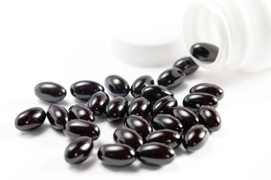 close-up pills spilling out of  pill bottle on white background