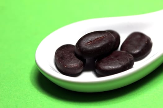 mocha beans on a porcelain spoon