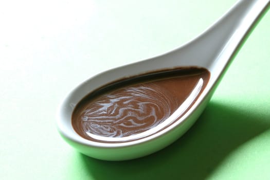 chocolate sauce on a porcelain spoon