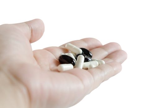many  pills spilling on hand with white background