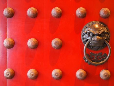 Red chinese door with a lion/dragon head.     