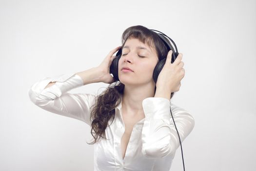 Portrait of a beautiful relaxed young woman enjoying music with eyes closed 
