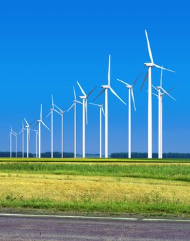 Beautiful green meadow with Wind turbines generating electricity