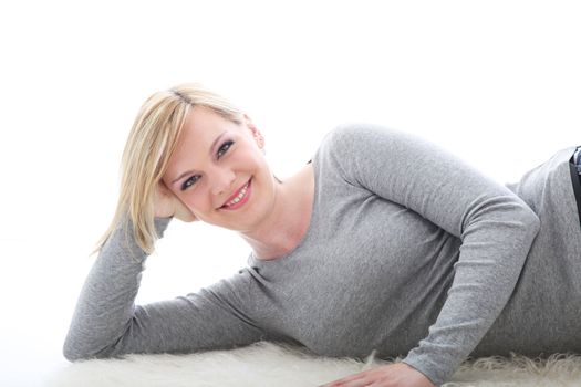 Relaxed smiling woman lying on white background