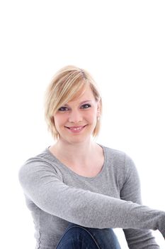 Relaxed friendly casual young woman smiling happily at the camera on a white background with copyspace
