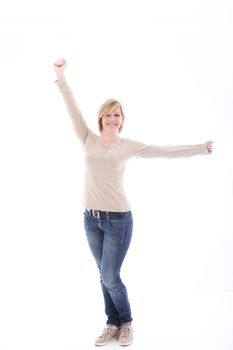 Carefree casual young woman in jeans stretching her arms in satisfaction and pleasure as she smiles cheerfully