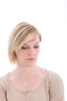 Somber sad young woman with downcast eyes and a serious expression isolated on white