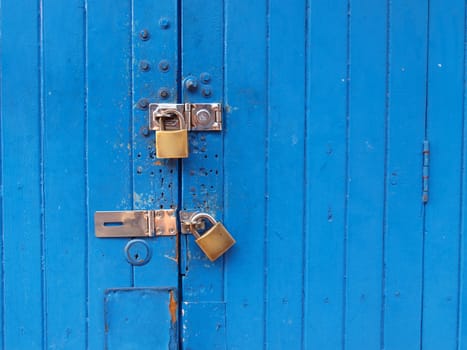 Locked blue door with a golden padlock	   