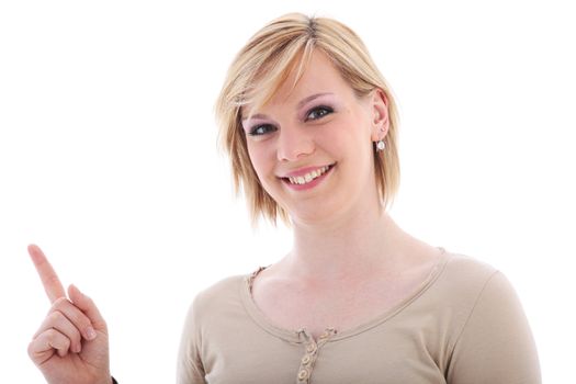 Attractive friendly smiling young saleslady pointing with her index finger to blank copyspace off frame at the left