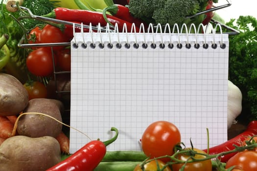 a checkered note pad and various vegetables