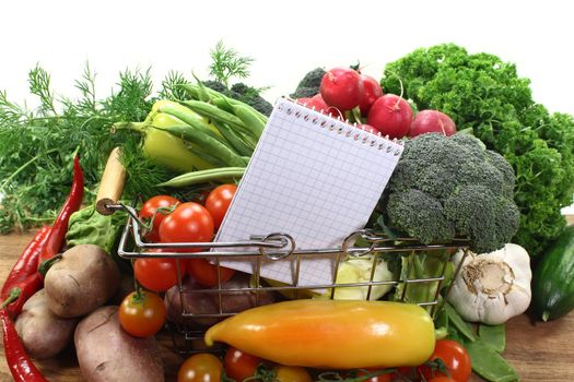 a checkered note pad and various vegetables