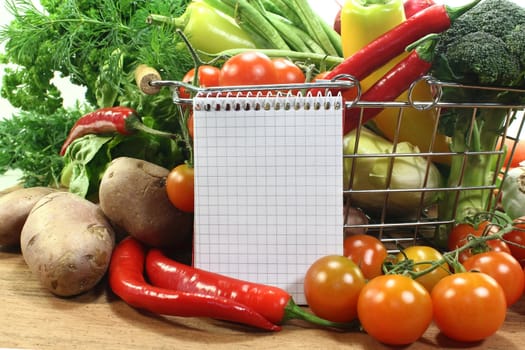 a checkered note pad and various vegetables